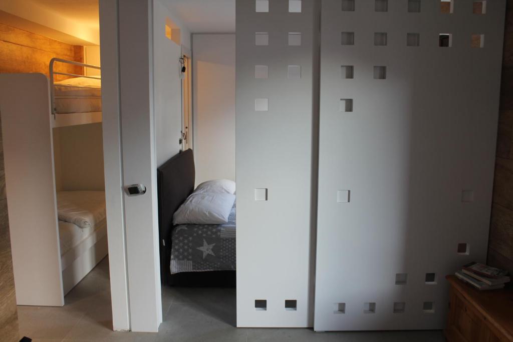 a bedroom with white walls and a bunk bed at Casa Coltura in Bormio