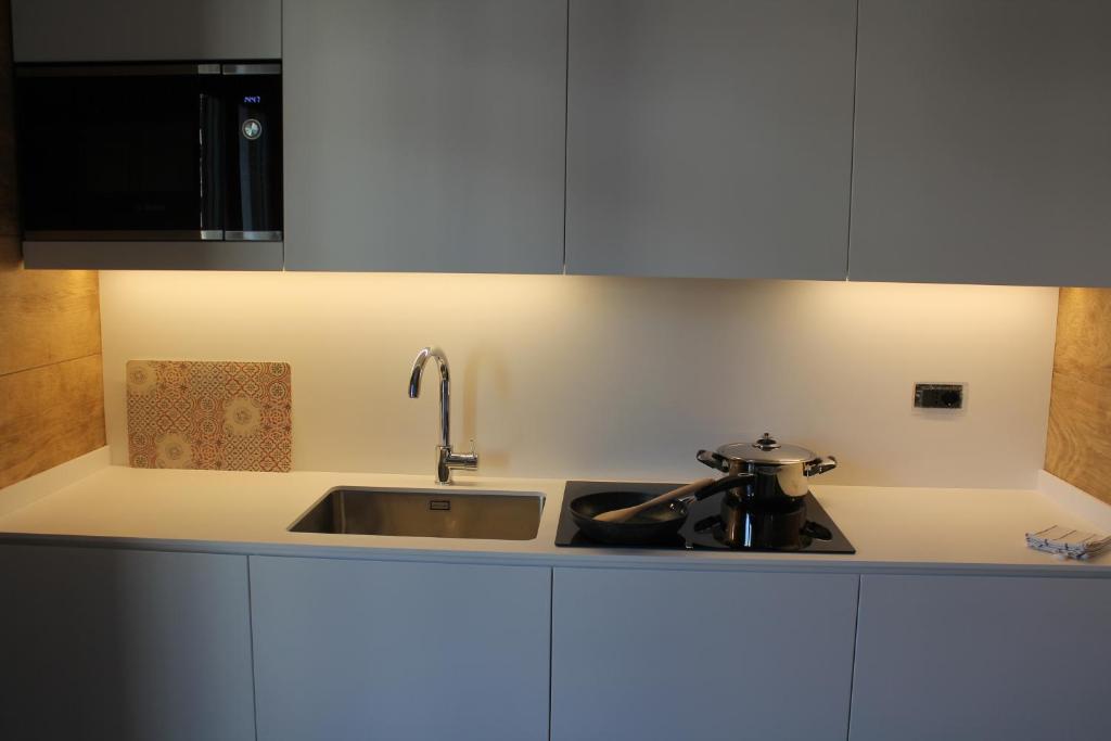 a kitchen with white cabinets and a sink at Casa Coltura in Bormio