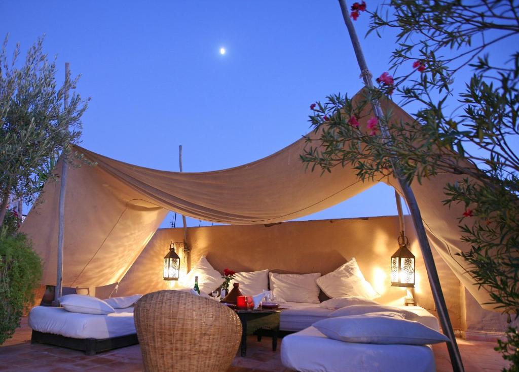 una tenda con divani bianchi, tavolo e luci di Riad O2 a Marrakech