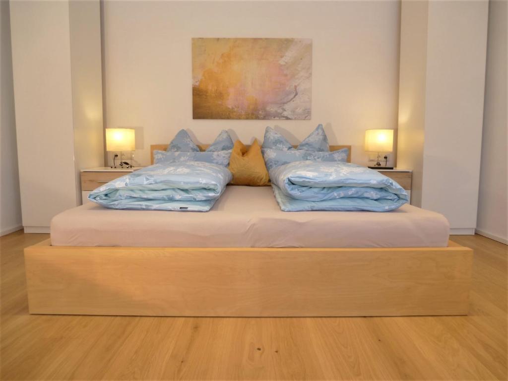 a bedroom with a bed with blue pillows on it at Cozy mountain view apartment with terrace and garden in Innsbruck