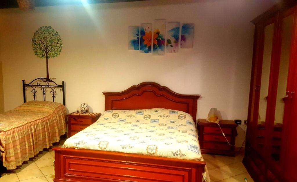 1 dormitorio con 1 cama y un árbol en la pared en B & B Luoghi Antichi, en Castrovillari