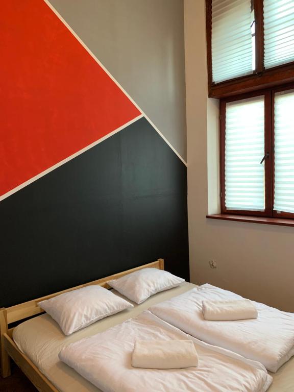 1 cama con 2 almohadas en una habitación con 2 ventanas en VIKI Kazimierz en Cracovia
