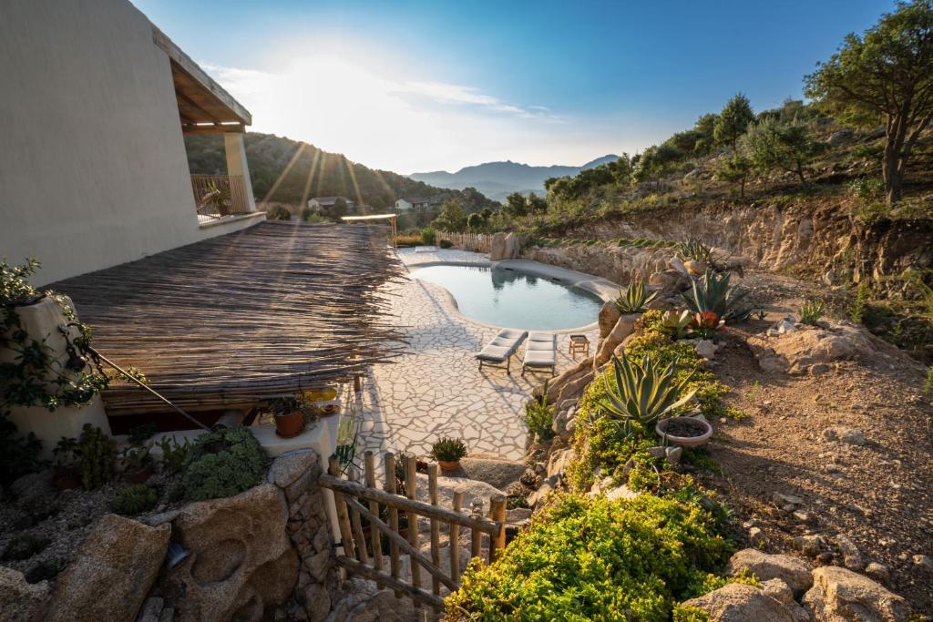 a wooden walkway leading to a pool of water at Casa Stones B&B in Cugnana