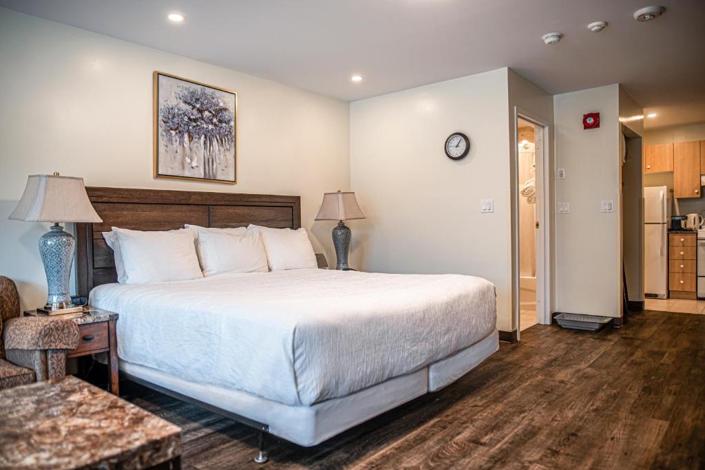 a bedroom with a large bed and a living room at The Business Inn in Ottawa