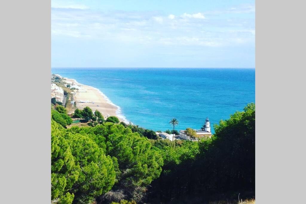a view of a beach with a lighthouse and the ocean at Calella Playa in Calella