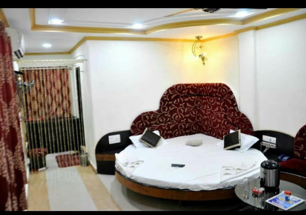 een kamer met een bed, een bank en een tafel bij Hotel Vijayshree in Pachmarhī