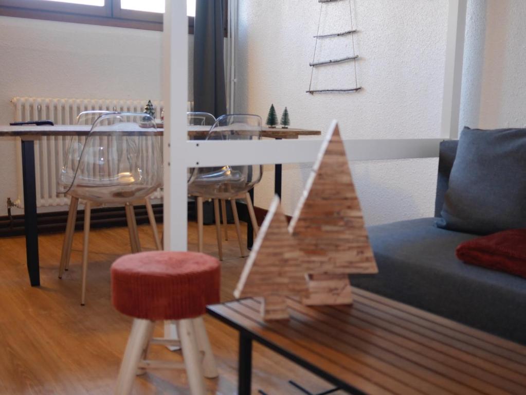 a living room with a couch and a table and chairs at Les studios de Chamrousse 1750 - Le Bellevue in Chamrousse