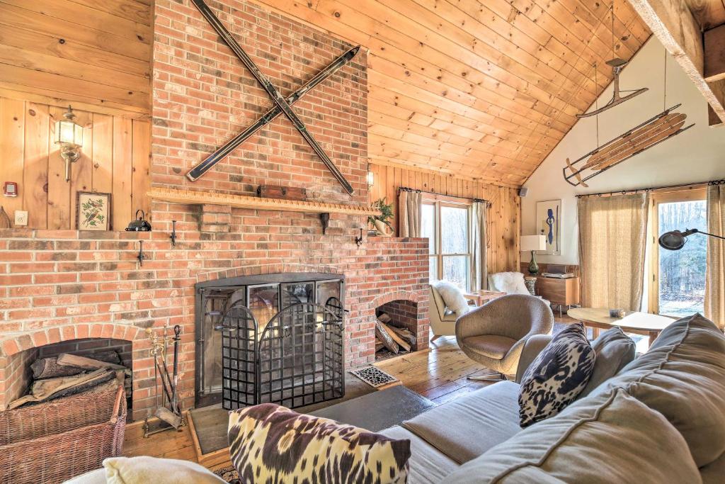 sala de estar con chimenea de ladrillo y sofá en Upscale Montgomery Cabin, Near Jay Peak Resort! en Montgomery