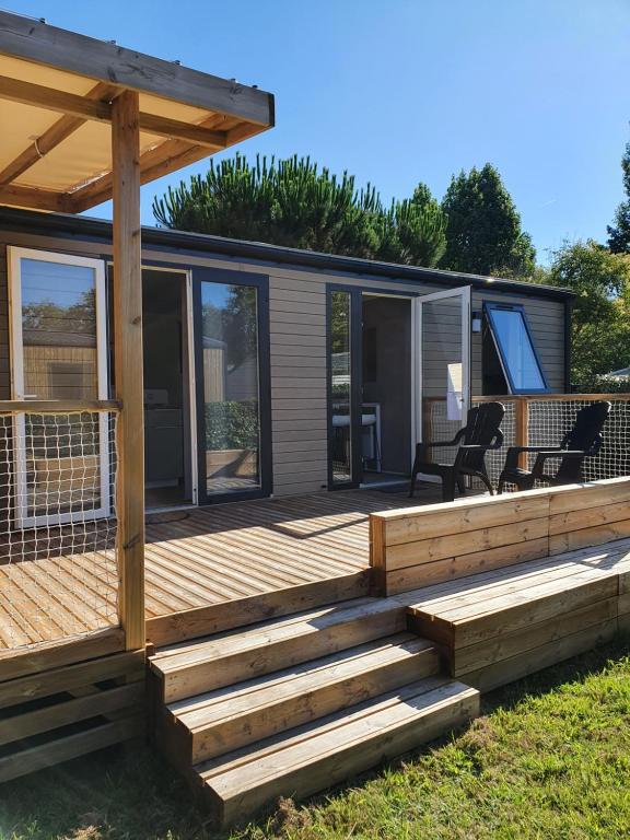 une maison avec une terrasse en bois et un patio dans l'établissement MOBIL-HOME OHARA 2020, à Biscarrosse