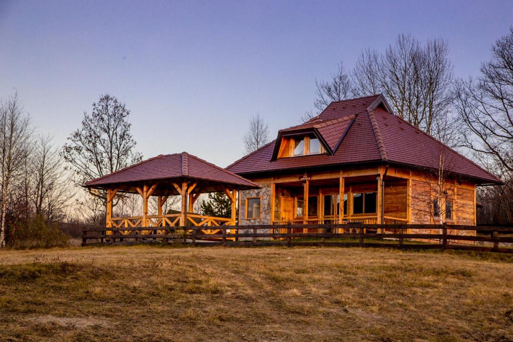 a log cabin with a gazebo in a field at Vikendica Martinovic in Zlatibor