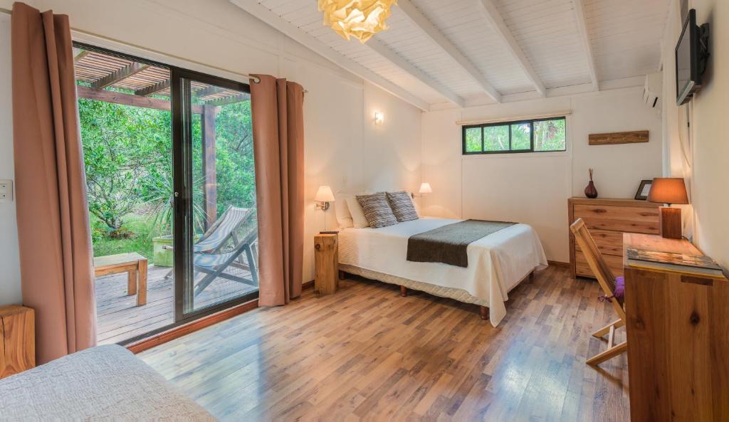 a bedroom with a bed and a sliding glass door at La Maison Suites & Gastronomía in La Paloma