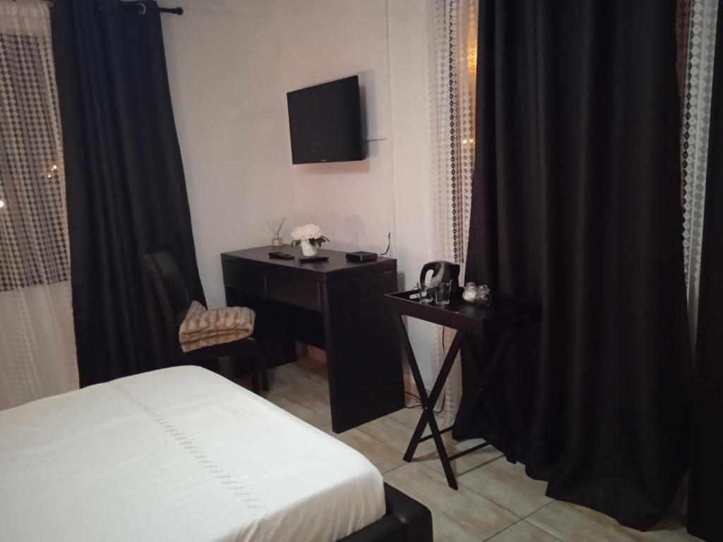 Dormitorio con cama, escritorio y TV en ILITHA PARK en Ciudad del Cabo