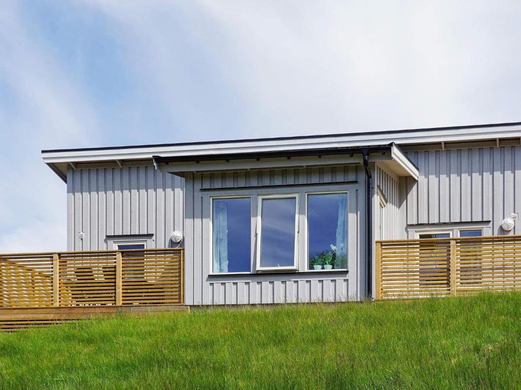 une maison avec une grande fenêtre et une clôture en bois dans l'établissement Holiday home STRÖMSTAD XVIII, à Strömstad