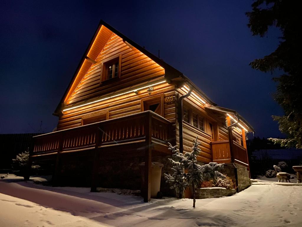 a log cabin with lights on it in the snow at Chata Filipsky in Ždiar