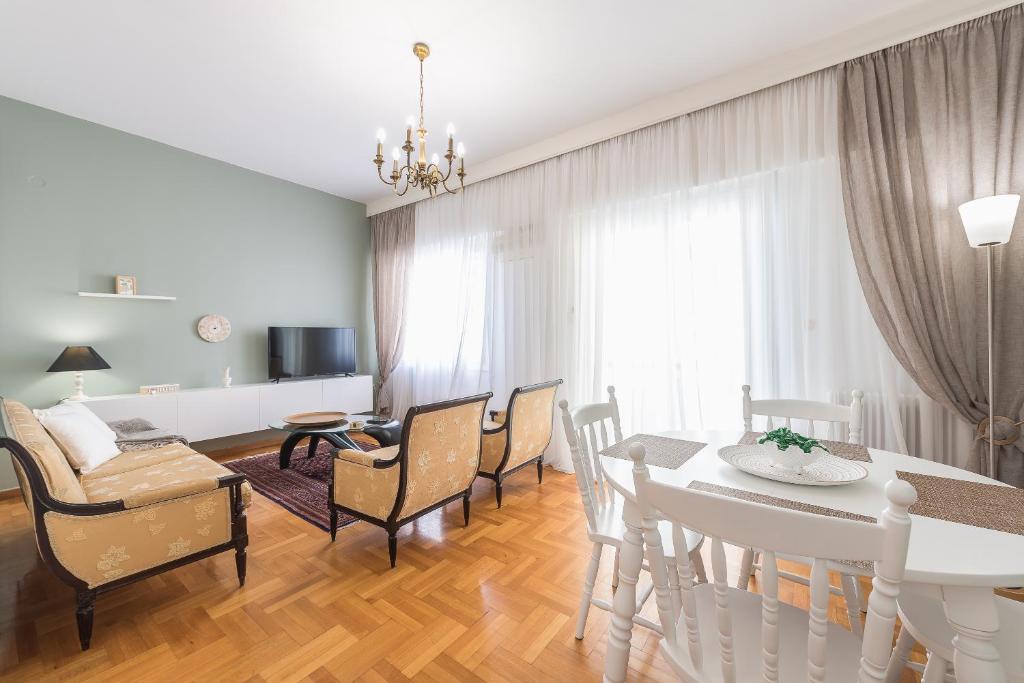 ein Esszimmer und ein Wohnzimmer mit einem Tisch und Stühlen in der Unterkunft Sophisticated Family House With Acropolis View in Athen