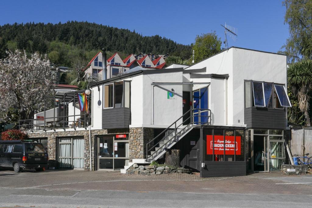 Un gran edificio blanco al costado de una calle. en Aspen Lodge Backpackers, en Queenstown