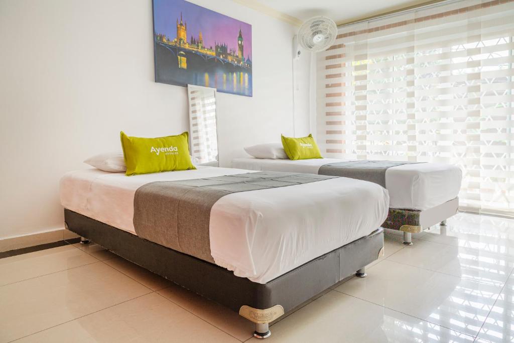 two twin beds in a room with a window at Ayenda 1258 Boutique Laureles Home in Medellín