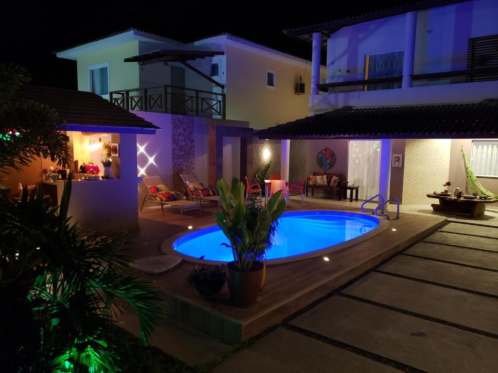 uma casa com piscina à noite em Excelente Duplex em Arembepe Aquaville - Bahia em Salvador