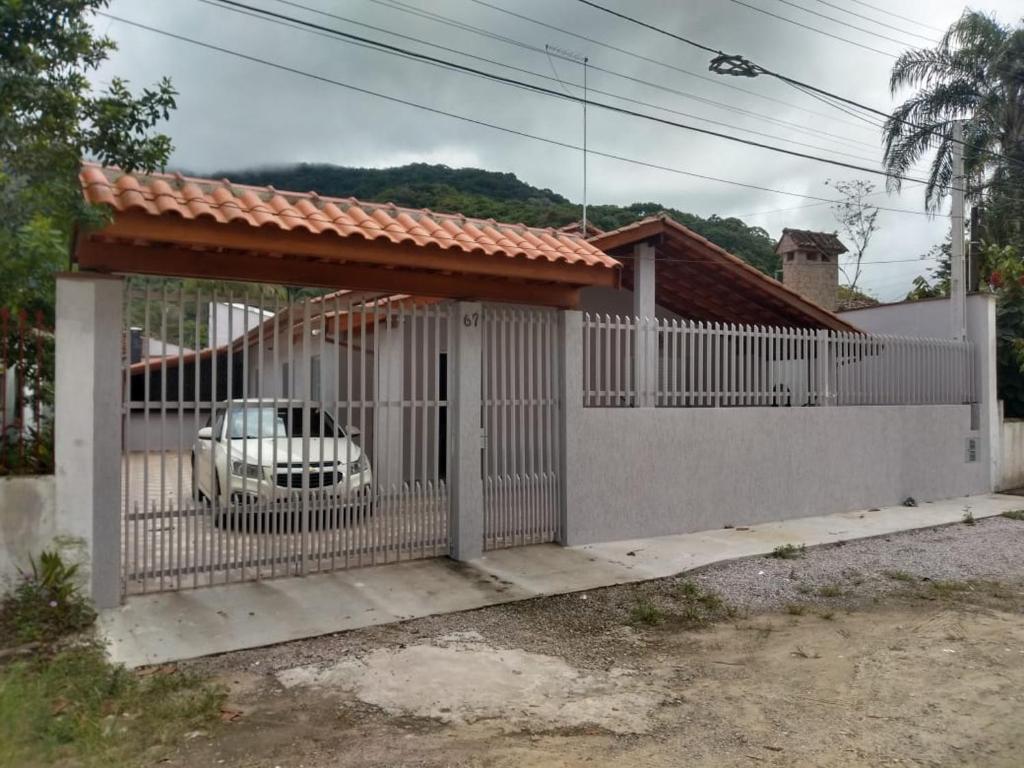 a white fence with a car inside of it at Casa Ubatuba Perequê Açu in Ubatuba