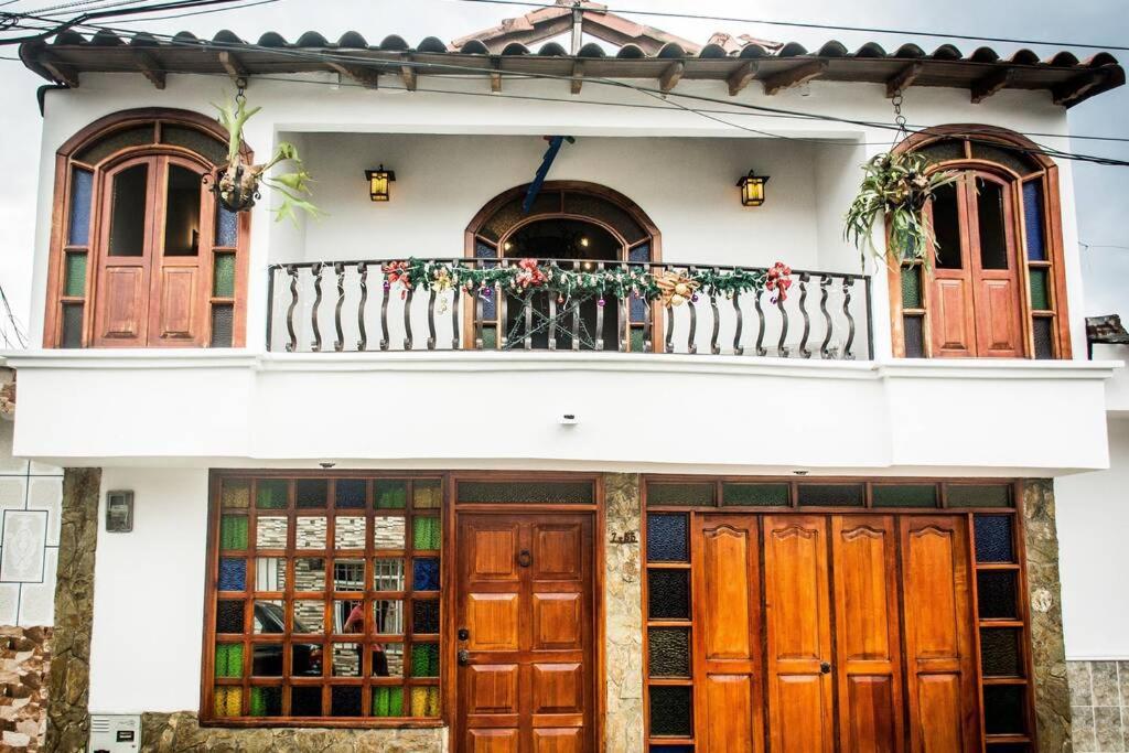 シルカシアにあるLos Tulios Alojamientoの木製のドアとバルコニーが備わる家
