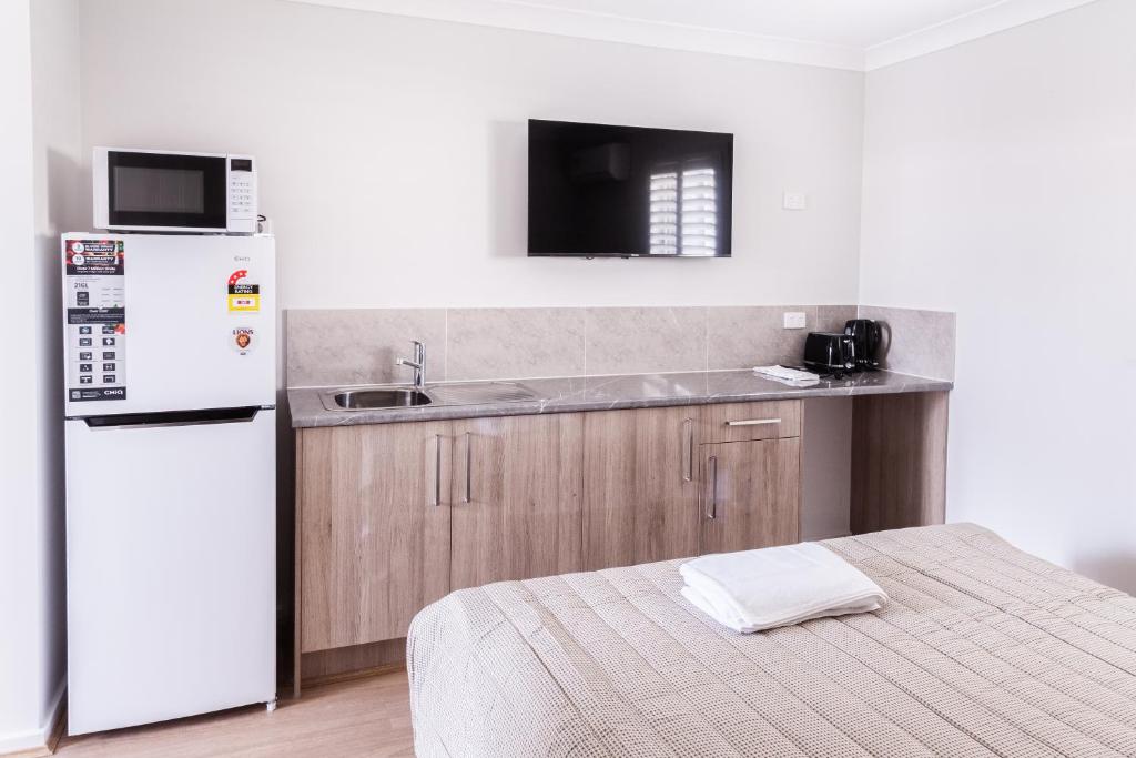 a kitchen with a white refrigerator and a sink at Singleton Valley Accommodation in Singleton