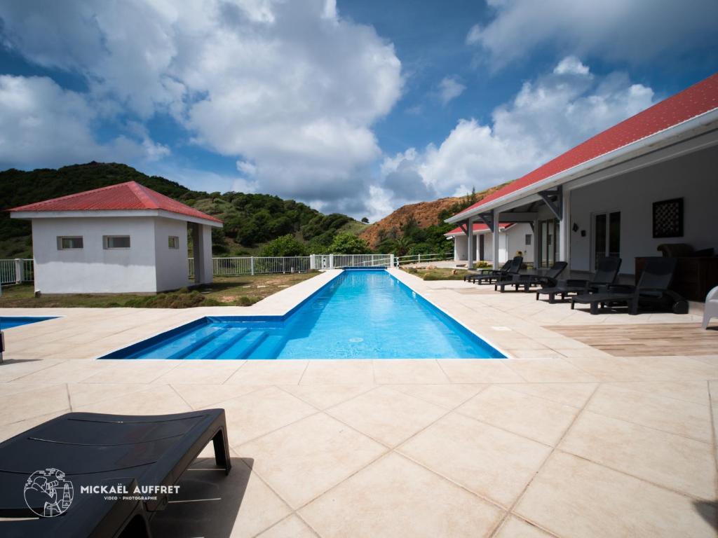 uma piscina ao lado de um edifício com uma casa em Grande villa avec piscine et jacuzzi em Terre-de-Haut