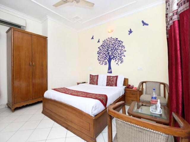 1 dormitorio con 1 cama con un árbol en la pared en Hotel Paradise Chandigarh, en Chandīgarh