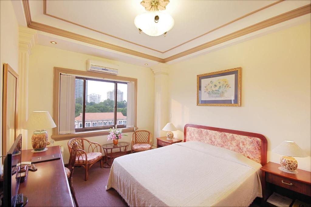 1 dormitorio con cama, escritorio y ventana en The Spring Hotel, en Ho Chi Minh
