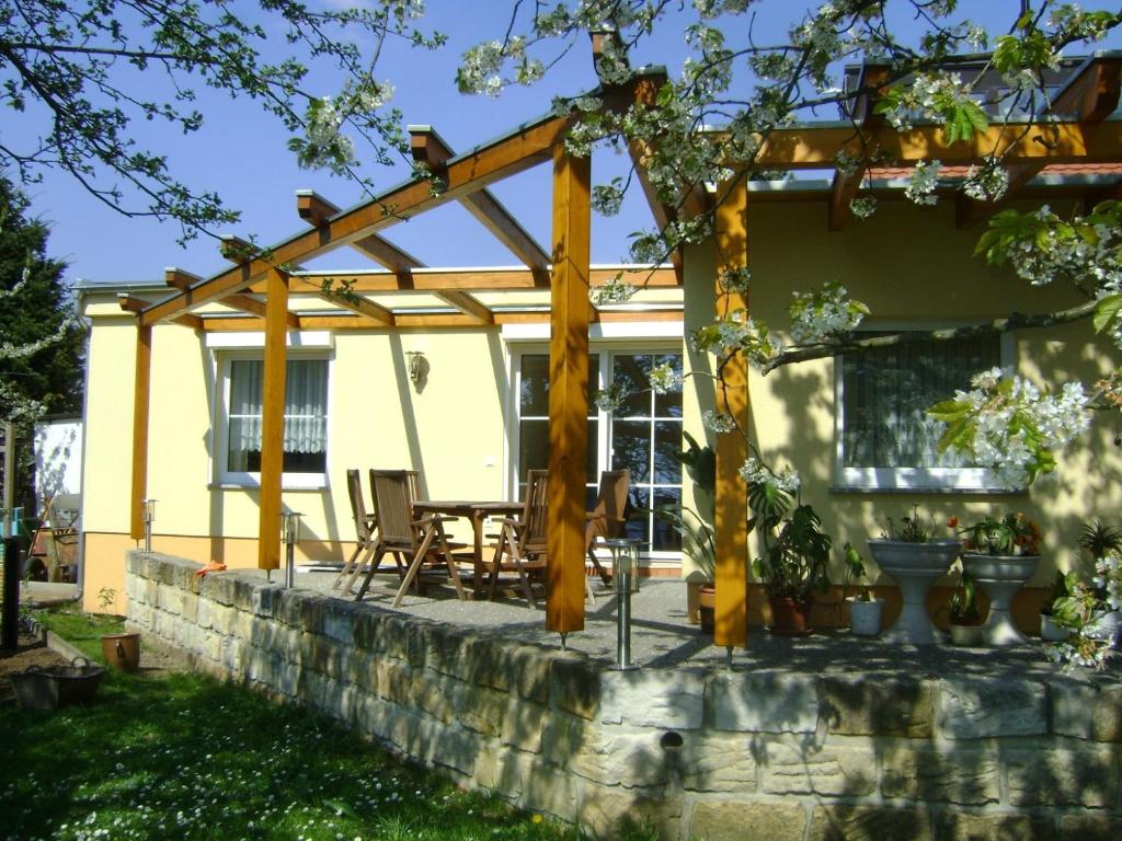 a pergola on a stone wall in front of a house at Ferienwohnung Hofeditz in Radeberg