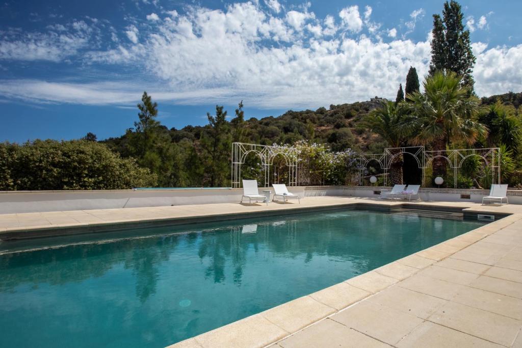 a swimming pool with two lawn chairs at Casa Di Angeli in Corbara