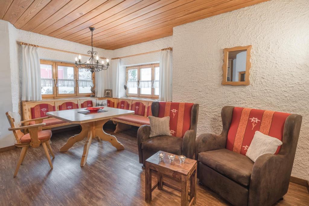 ein Wohnzimmer mit einem Tisch und Stühlen in der Unterkunft Ferienwohnungen Alpentraum - Landhaus am Bächle in Oberstdorf