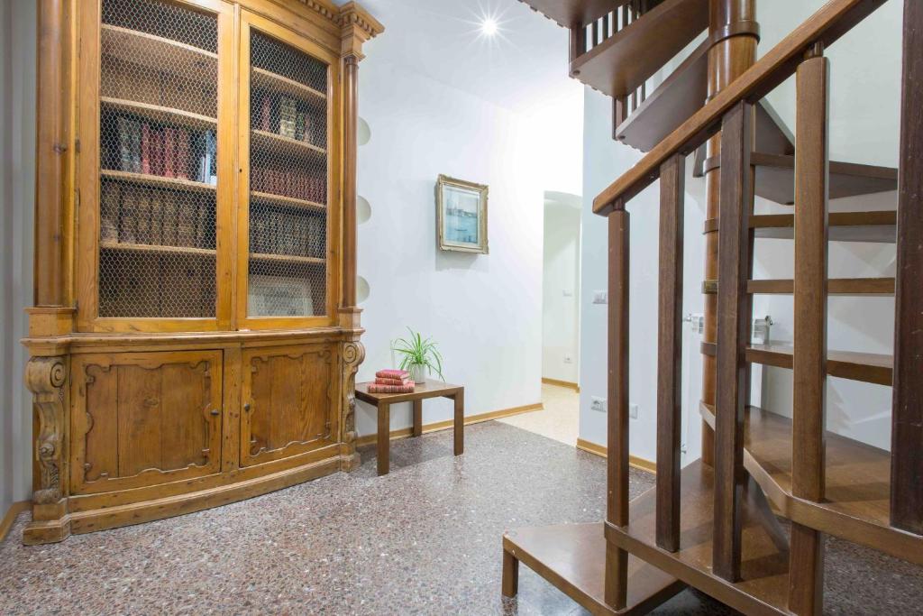 duża drewniana szafka w pokoju ze schodami w obiekcie CA GRIMANI private terrace w Wenecji