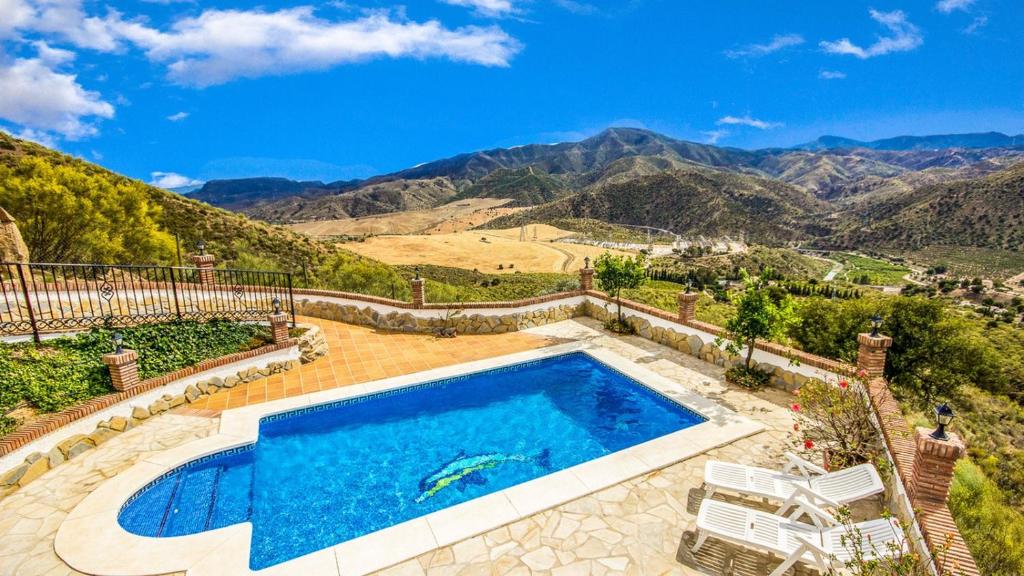 una piscina al aire libre con vistas a las montañas en Casa El Algarrobo Alora by Ruralidays, en Álora