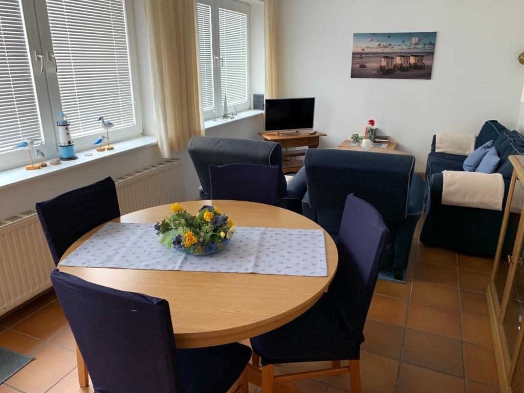 a room with a table and chairs and a living room at Frisiastraße 21 in Norderney