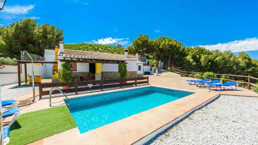 une villa avec une piscine en face d'une maison dans l'établissement Casa Lagar El Mirador Almachar by Ruralidays, à Almáchar