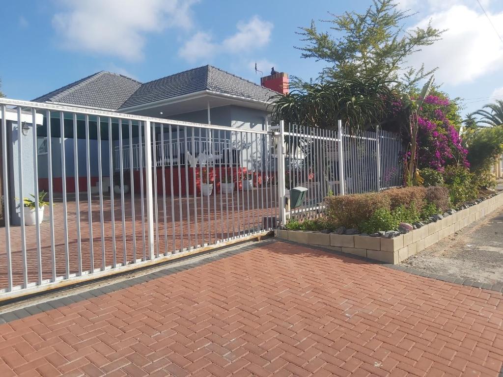una recinzione bianca di fronte a una casa di izuba lodge a Città del Capo