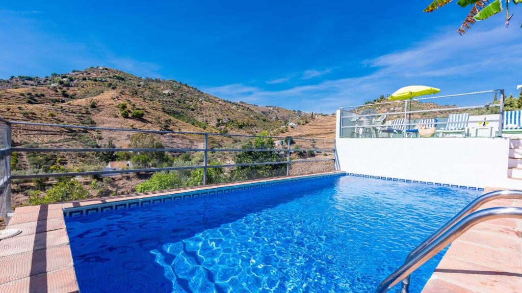 een zwembad met een berg op de achtergrond bij Casa Ameli Competa by Ruralidays in Cómpeta