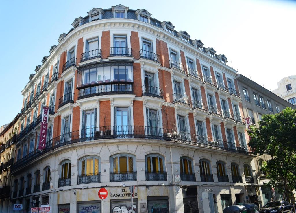 a large white building with balconies on a street at Hostal San Lorenzo in Madrid