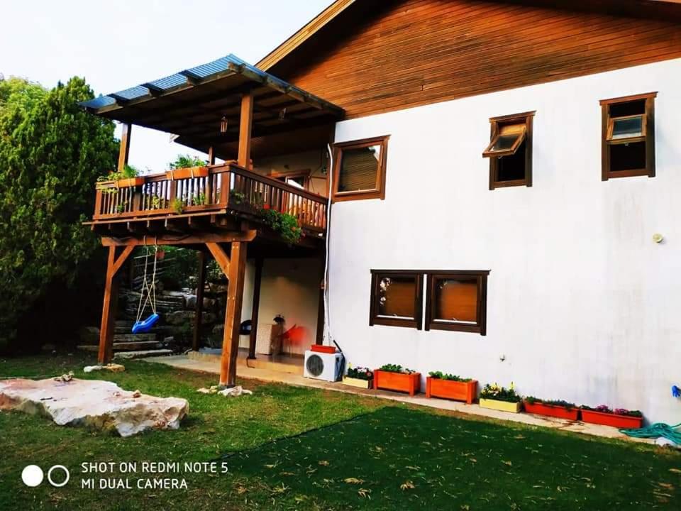 una casa con una terraza a un lado en אירוח בכפר ורדים גברת פלפלת en Kefar Weradim