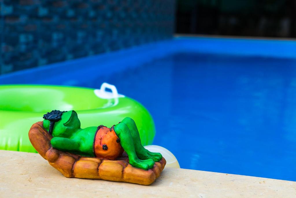 mała figurka osoby leżącej na hot dogu w obiekcie Lazy Frog Guest House w mieście Cavelossim