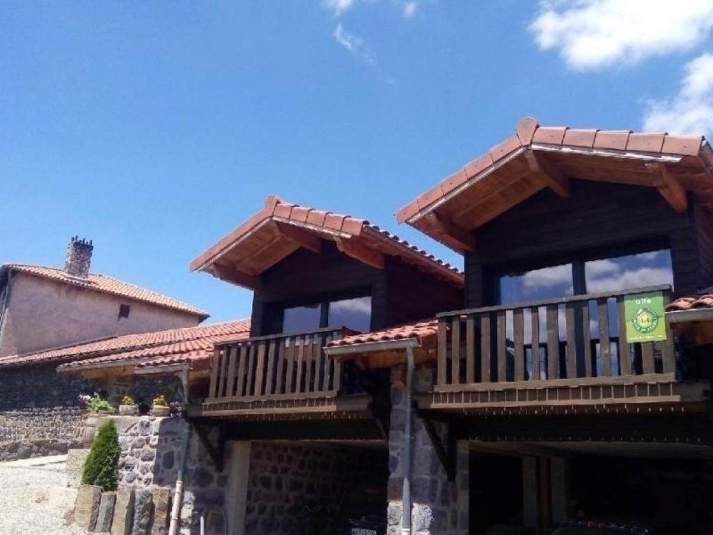 a house with wooden balconies on top of it at Gîte confortable près de la Cascade de la Beaume avec terrasses et parking privatif - FR-1-582-30 in Solignac-sur-Loire