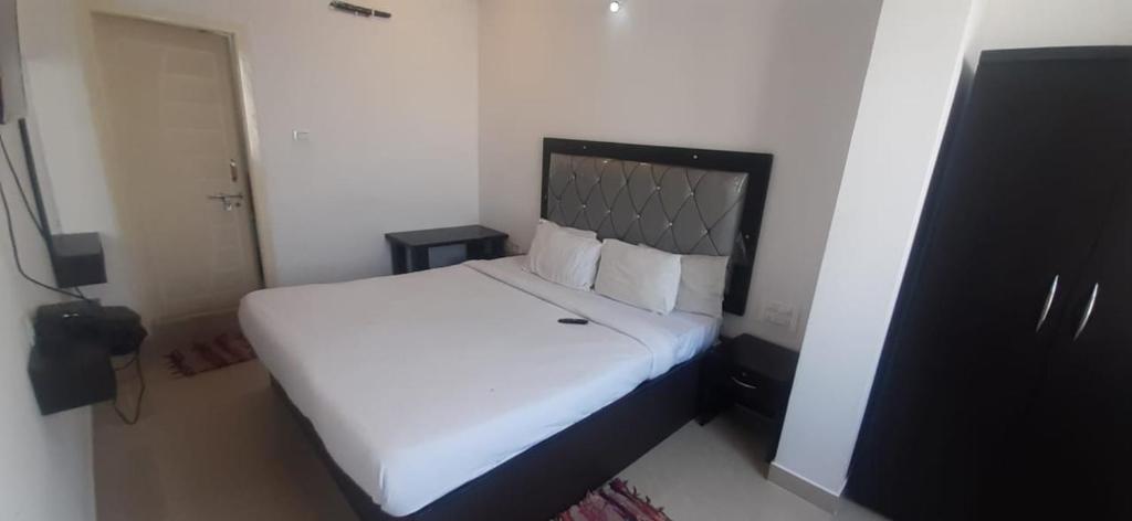um quarto com uma grande cama branca num quarto em PPH Living SS Grand em Shamshabad