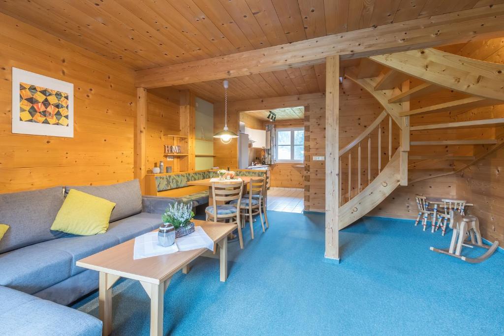 a living room with a couch and a staircase at Därfli Appartements in Sankt Gallenkirch