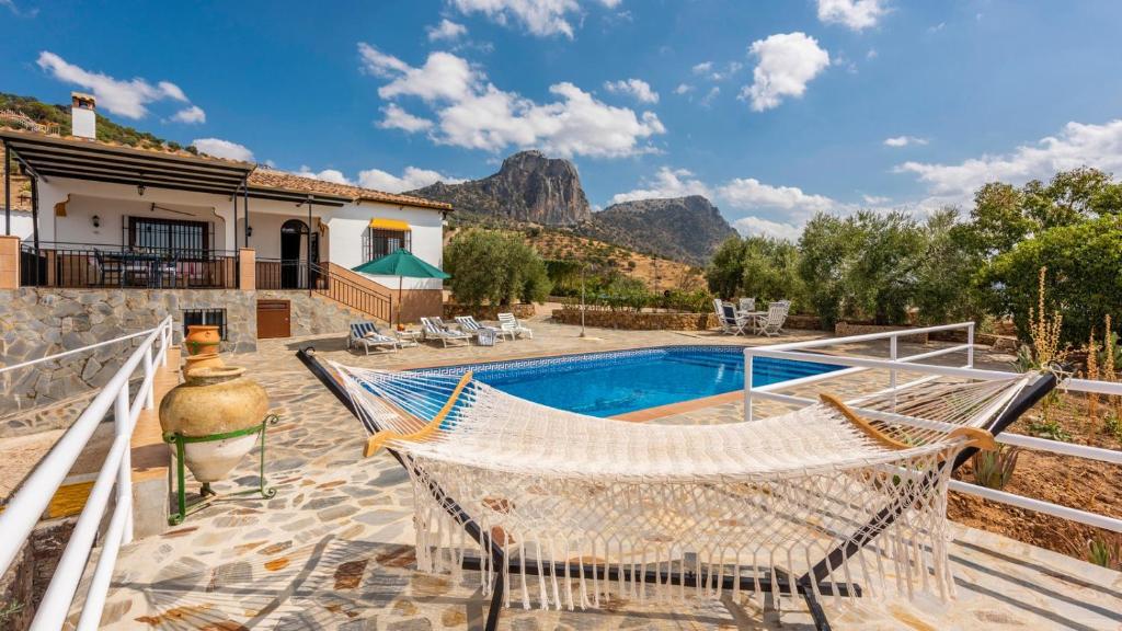 a patio with a hammock and a swimming pool at Casa Los Marjales El Gastor by Ruralidays in El Gastor