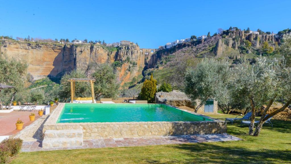 a swimming pool with a mountain in the background at Casa El Puente Ronda by Ruralidays in Ronda