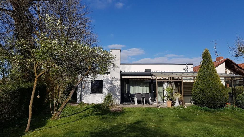 a white house with a lawn and trees at Ferienhaus Brenzblick in Gundelfingen