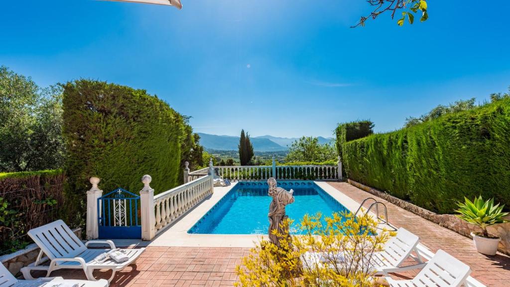 - une piscine dans une cour avec 2 chaises blanches dans l'établissement Casa El Parque de Isabel Prado del Rey by Ruralidays, à Prado del Rey