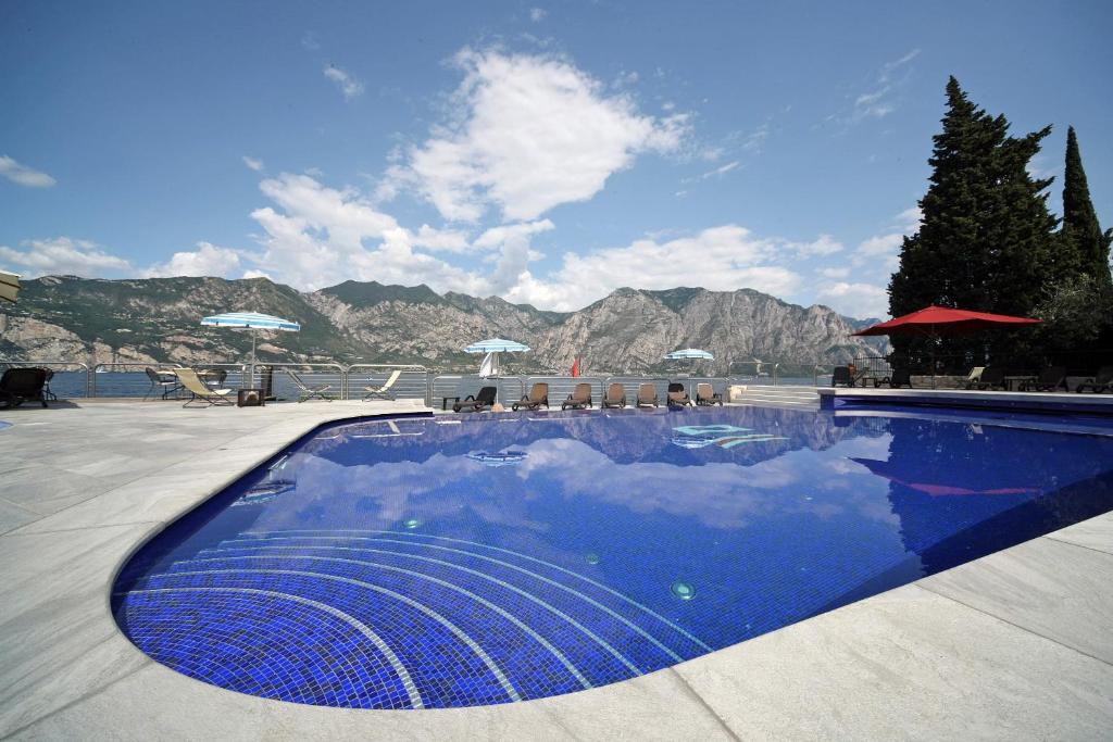 a swimming pool with a reflection of the sky at Hotel Sailing Center in Malcesine