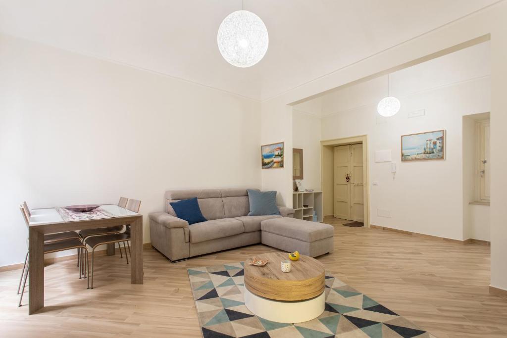 ein Wohnzimmer mit einem Sofa und einem Tisch in der Unterkunft Appartamento al Consiglio Reginale by Wonderful Italy in Syrakus