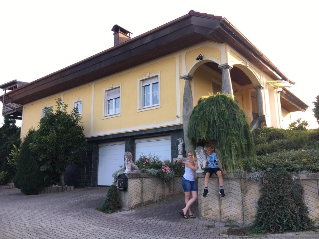 uma mulher e duas crianças em pé em frente a uma casa em EKO-Hof em Mitterlabill